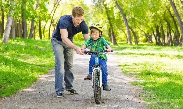 Riding a child on a two-wheeled bicycle